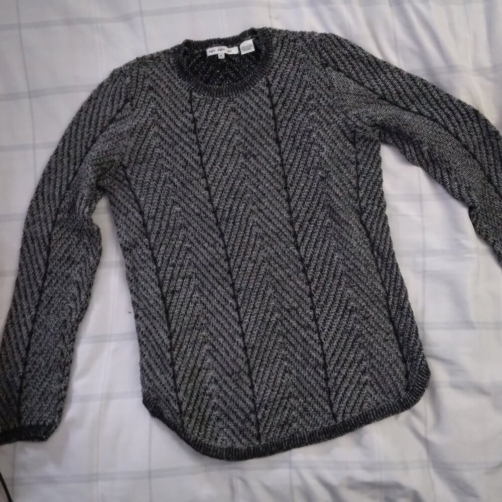 A 100% cotton black and gray sweater with rounded hem